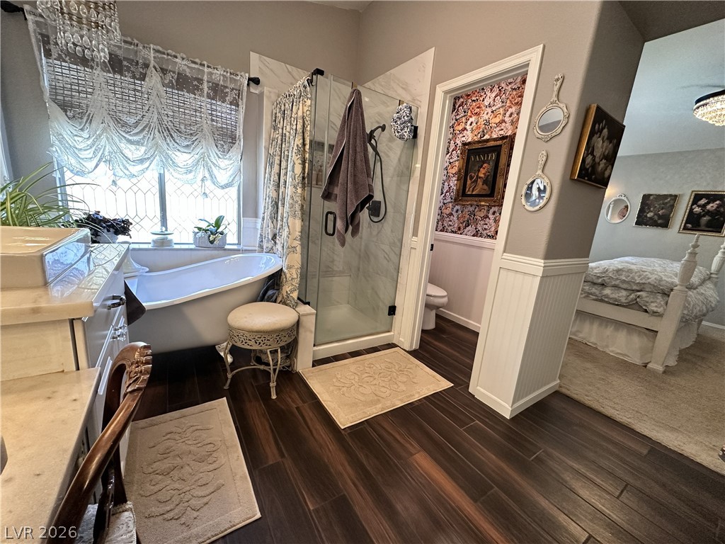 9724 Trail Rider Drive Las Vegas, NV 89117 - Photo 39 of 52 Ensuite bathroom with wainscoting, a shower stall, a soaking tub, dark wood-style floors, and vanity