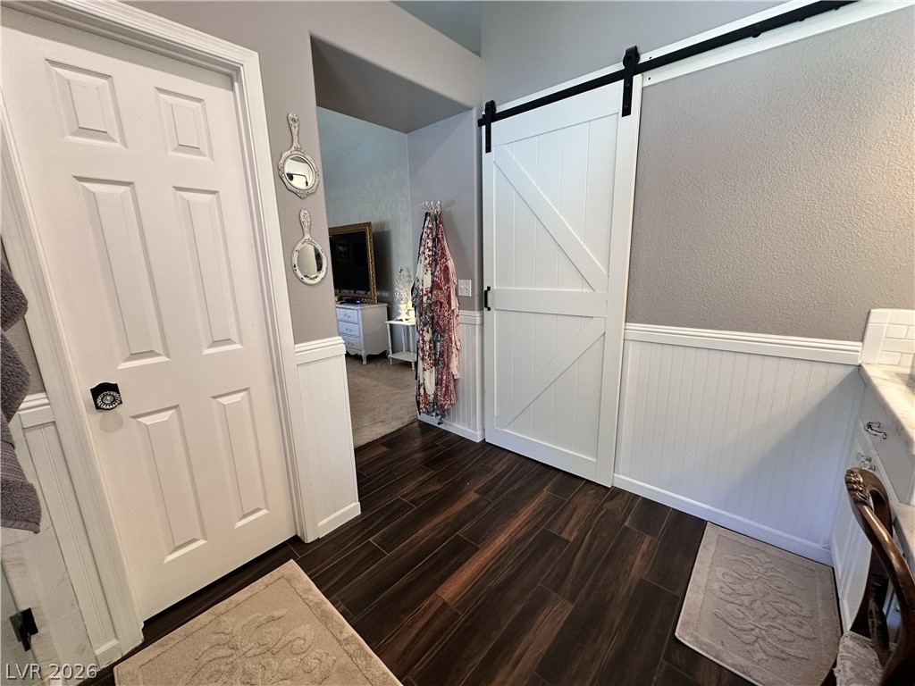 9724 Trail Rider Drive Las Vegas, NV 89117 - Photo 42 of 52 Bathroom featuring a wainscoted wall, dark wood-type flooring, and vanity