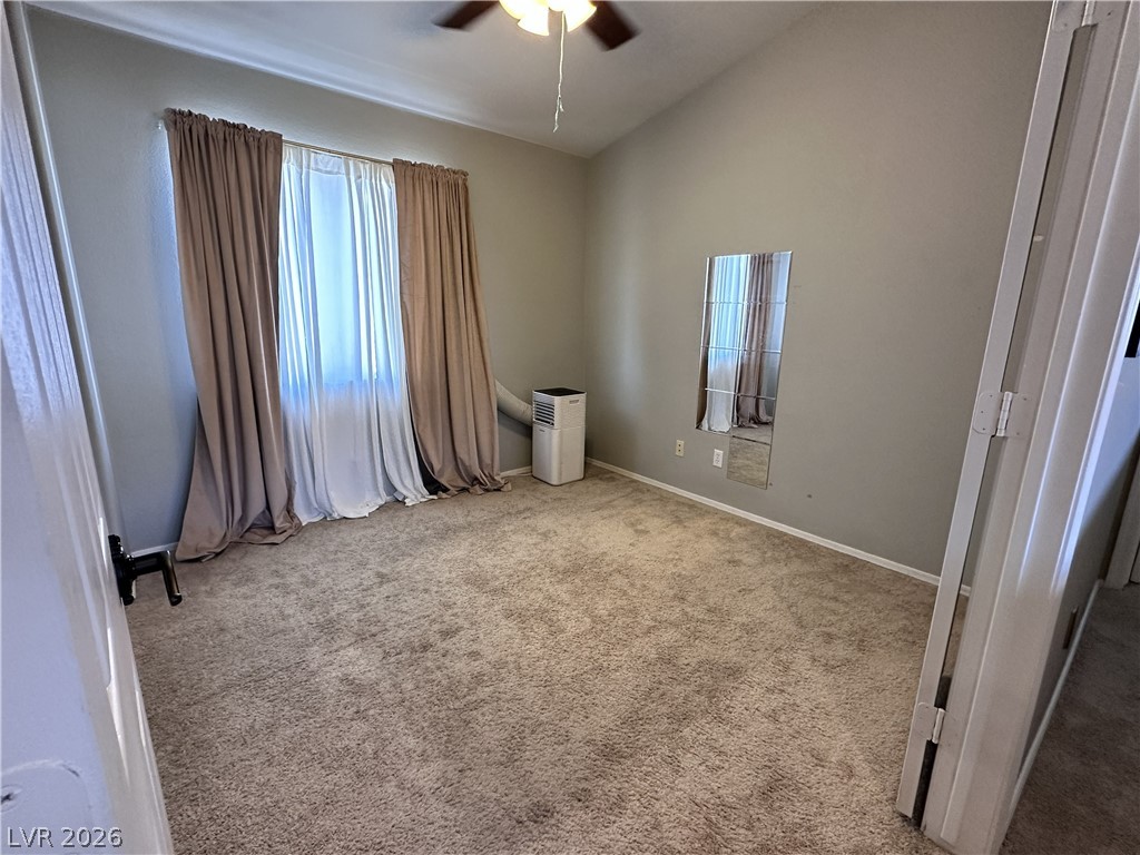 9724 Trail Rider Drive Las Vegas, NV 89117 - Photo 48 of 52 Unfurnished bedroom featuring vaulted ceiling, ceiling fan, light carpet, and multiple windows