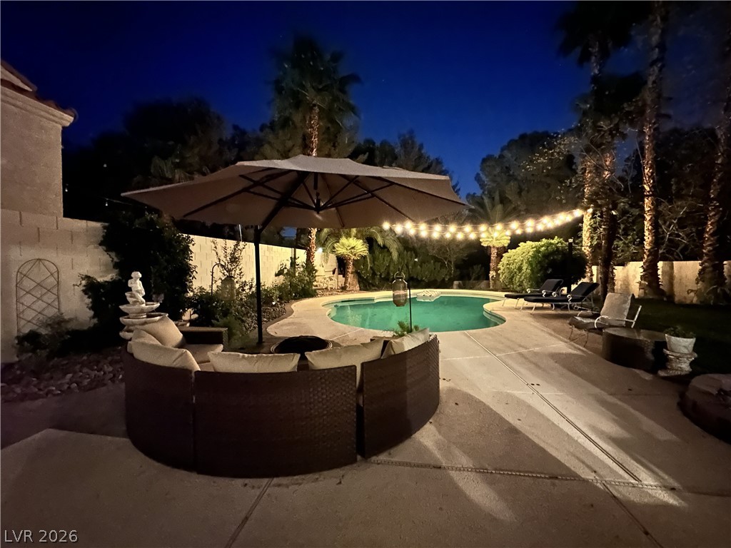 9724 Trail Rider Drive Las Vegas, NV 89117 - Photo 52 of 52 Pool at night featuring a patio, a fenced backyard, and outdoor lounge area