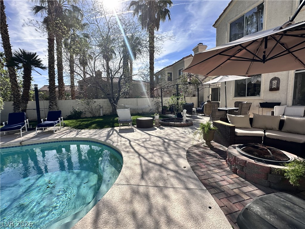 9724 Trail Rider Drive Las Vegas, NV 89117 - Photo 9 of 52 View of pool featuring patio surround, an outdoor living space with a fire pit, and a fenced backyard
