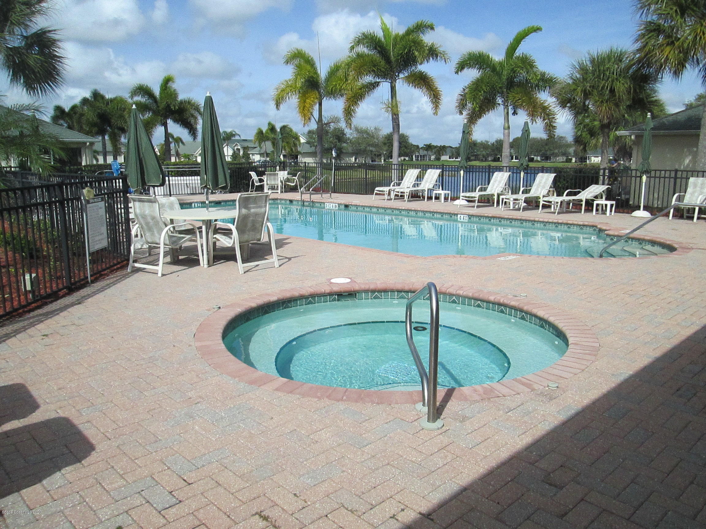 3652 Shawnee Lane Melbourne, FL 32901 - Photo 30 of 34 a small pool with lawn chairs and palm tree