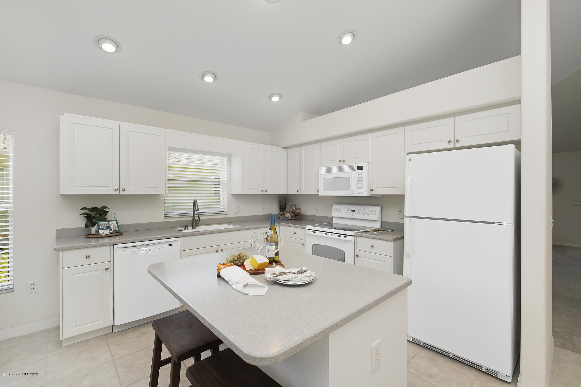 3652 Shawnee Lane Melbourne, FL 32901 - Photo 7 of 34 a kitchen with a sink a stove a refrigerator and white cabinets
