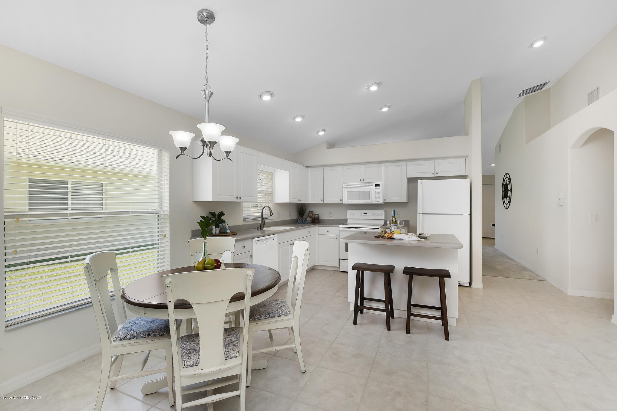 3652 Shawnee Lane Melbourne, FL 32901 - Photo 10 of 34 a dining room with stainless steel appliances kitchen island a table and chairs
