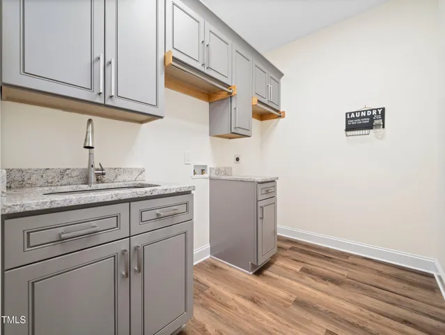 a kitchen with granite countertop cabinets stainless steel appliances and a wooden floor