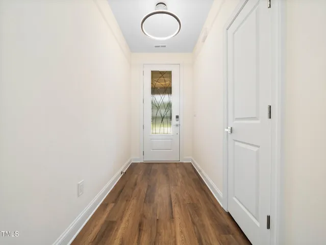 a view of a room with wooden floor and white walls