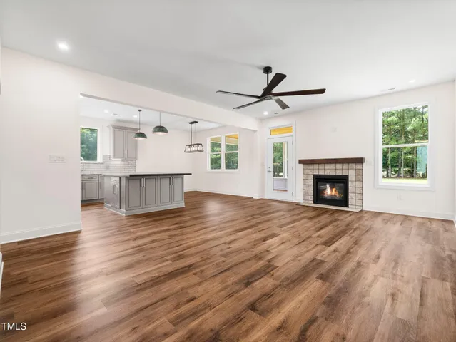 a view of empty room with wooden floor and fireplace