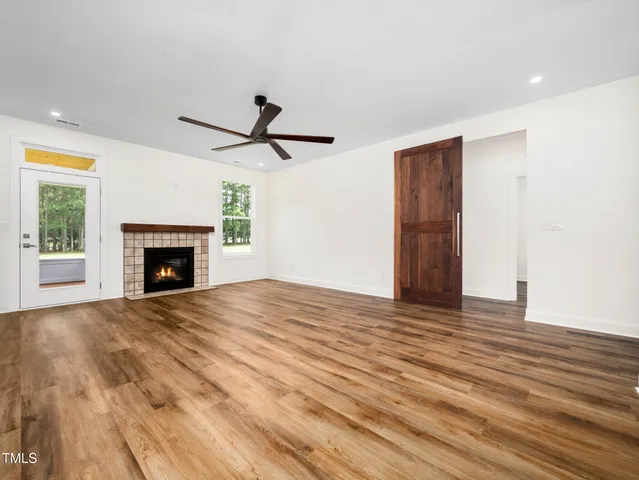 a view of empty room with wooden floor and fireplace
