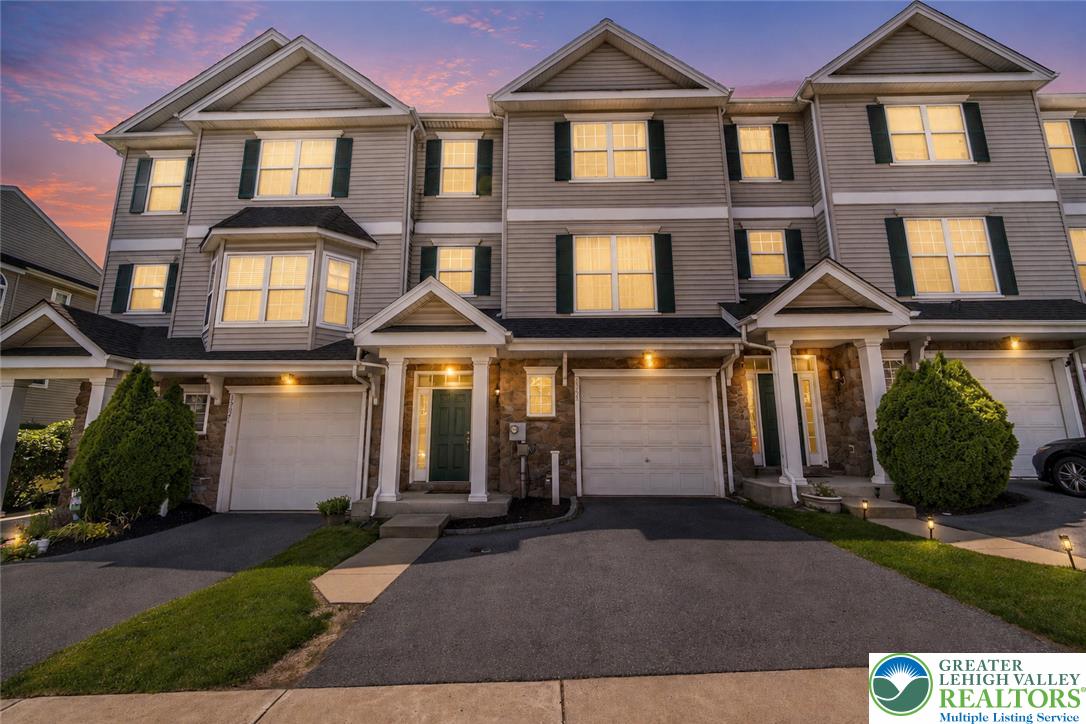 3566 Penfield Way Nazareth, PA 18064 - Photo 1 of 47 Modern townhome features attached garage under a vibrant evening sky.