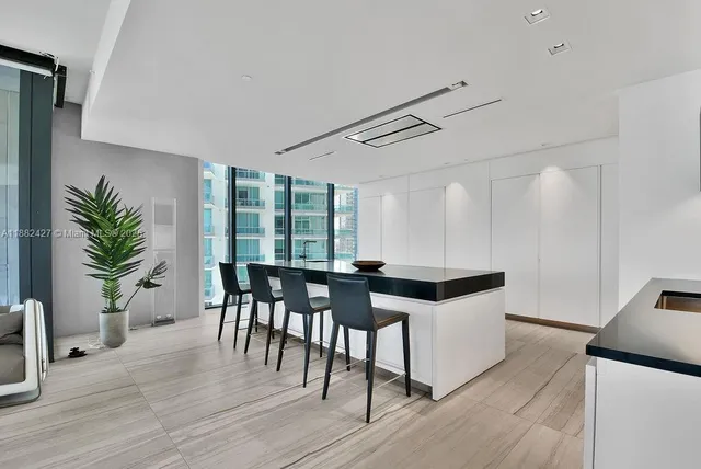 a view of living room kitchen with stainless steel appliances kitchen island a stove and a large window