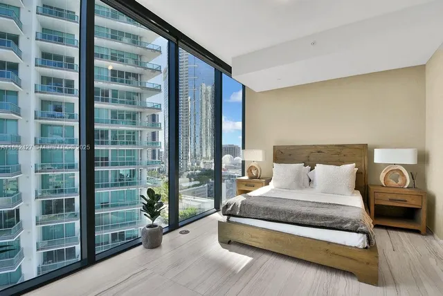 a bedroom with a bed couch and potted plant on the dresser