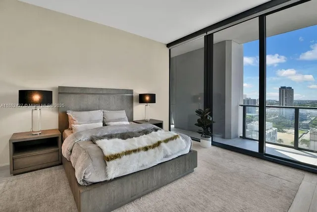 a bedroom with a bed and a large window