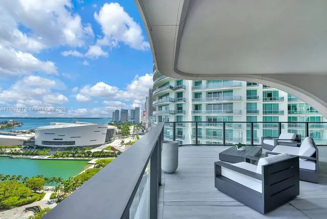 a view of a balcony with furniture and a garden