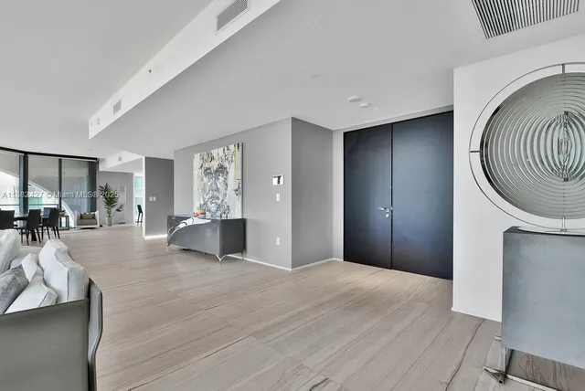 a living room with furniture a floor to ceiling window and a flat screen tv