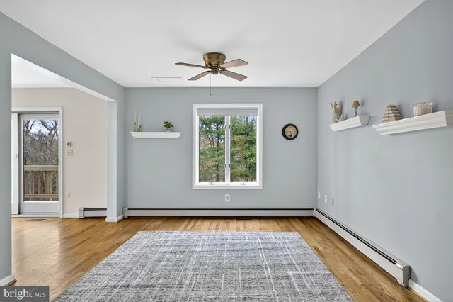 a view of an empty room with chandelier fan