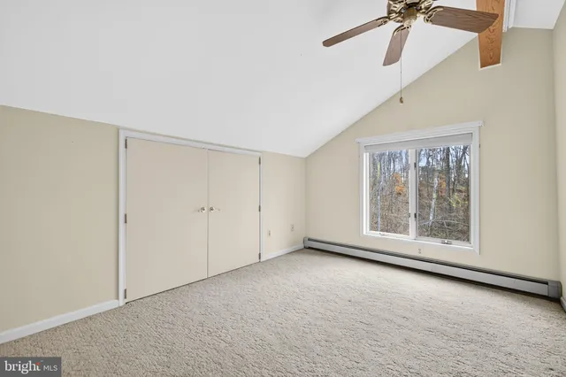 a view of swimming pool with large trees and wooden fence