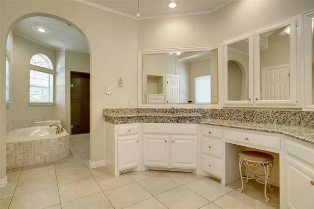 a bathroom with a granite countertop sink mirror and bathtub