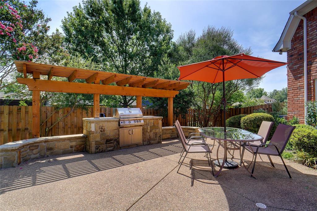 203 Donley Court Southlake, TX 76092 - Photo 5 of 21 a patio with a table and chairs under an umbrella