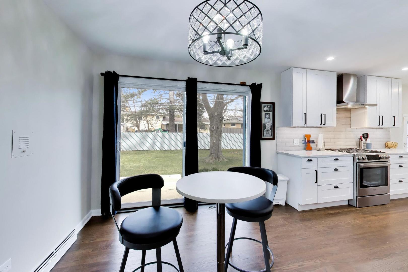 108 West Sunset Road Mount Prospect, IL 60056 - Photo 13 of 40 a kitchen with stainless steel appliances a table and chairs in it