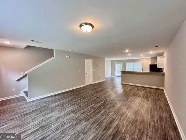 a view of an empty room with wooden floor