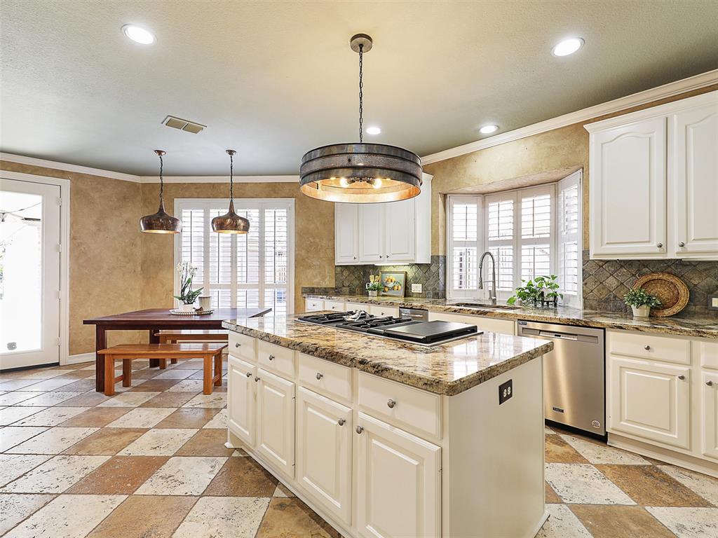 723 Bent Tree Court Coppell, TX 75019 - Photo 11 of 39 a kitchen with a stove a sink a dining table and chairs