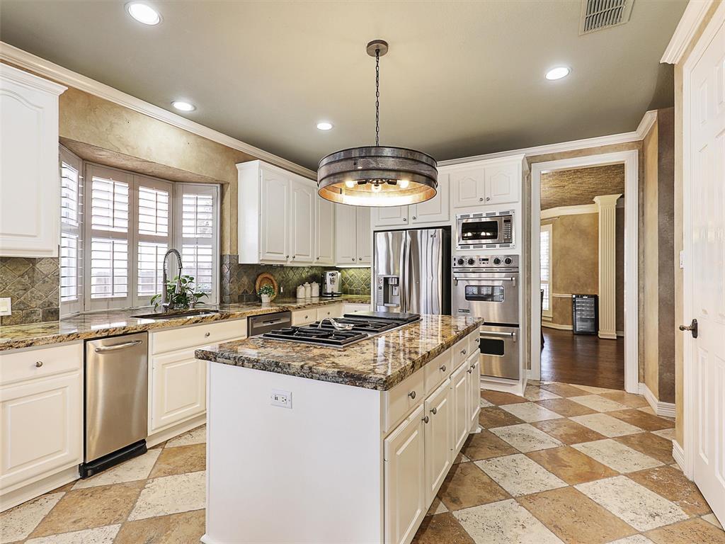 723 Bent Tree Court Coppell, TX 75019 - Photo 12 of 39 a kitchen with stainless steel appliances granite countertop a stove a sink a refrigerator and a granite counter tops with a large window