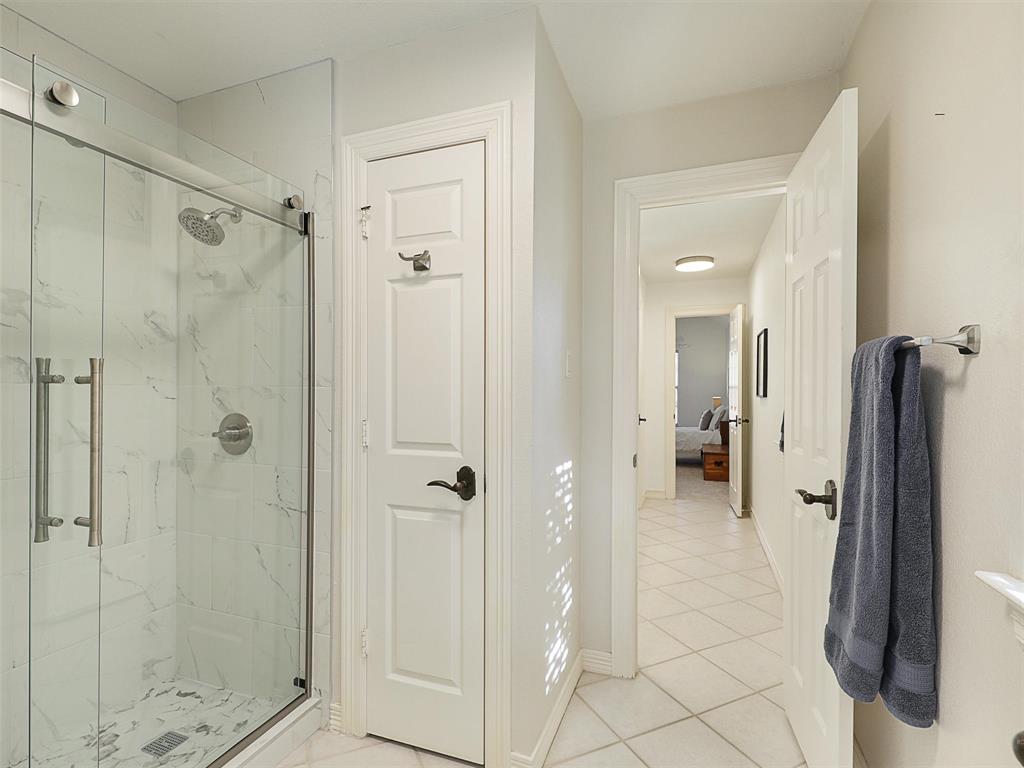 723 Bent Tree Court Coppell, TX 75019 - Photo 30 of 39 a bathroom with a shower and a glass door