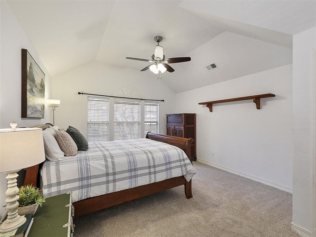 723 Bent Tree Court Coppell, TX 75019 - Photo 34 of 39 a bedroom with a bed chandelier and a window