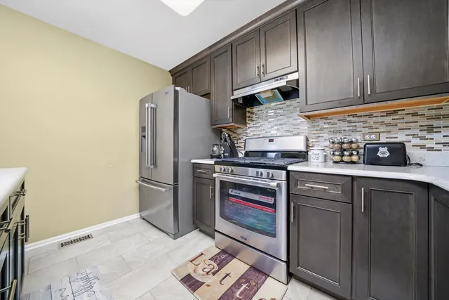 a kitchen with stainless steel appliances granite countertop a refrigerator and a stove top oven