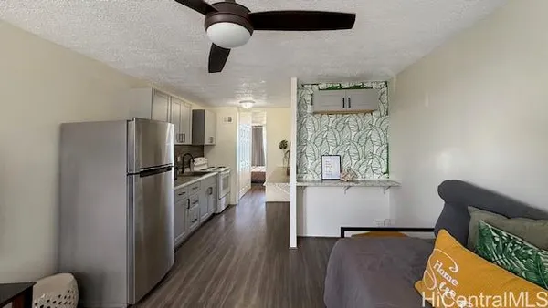 a kitchen with a refrigerator cabinets and wooden floor