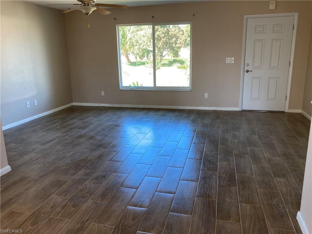 4590 28th Avenue Southwest Naples, FL 34116 - Photo 17 of 37 an empty room with wooden floor and windows
