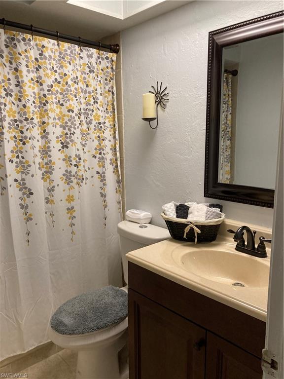 4590 28th Avenue Southwest Naples, FL 34116 - Photo 20 of 37 a bathroom with a sink a toilet and a mirror