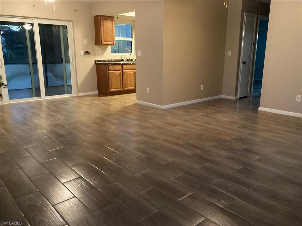 4590 28th Avenue Southwest Naples, FL 34116 - Photo 29 of 37 a kitchen with granite countertop a sink cabinets and stainless steel appliances