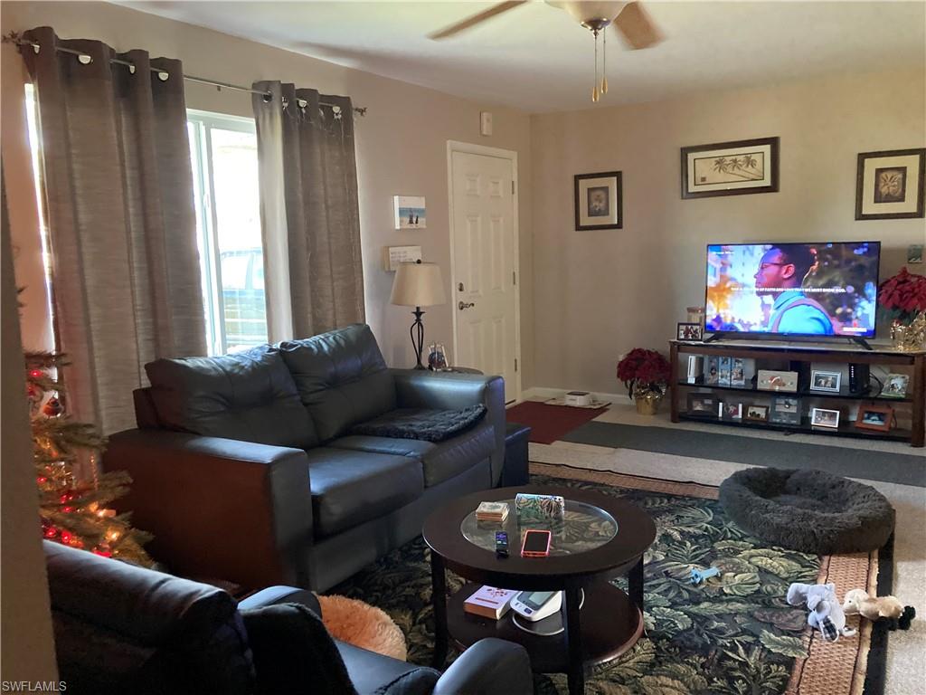 4590 28th Avenue Southwest Naples, FL 34116 - Photo 35 of 37 a living room with furniture and a flat screen tv