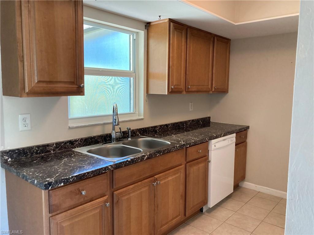 4590 28th Avenue Southwest Naples, FL 34116 - Photo 4 of 37 a kitchen with granite countertop a sink and a white cabinets