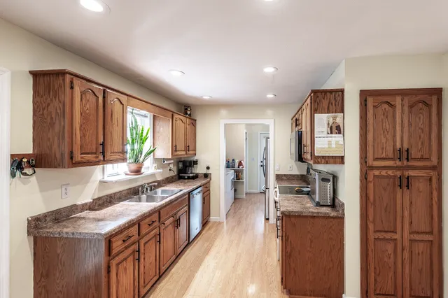 a kitchen with stainless steel appliances granite countertop lots of counter top space and wooden floor