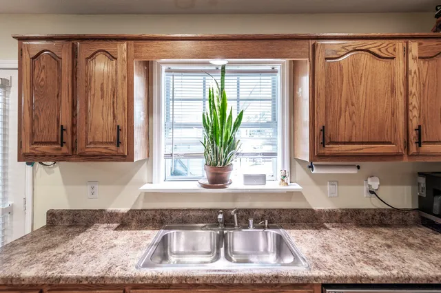 a view of a kitchen with granite countertop a sink and a window