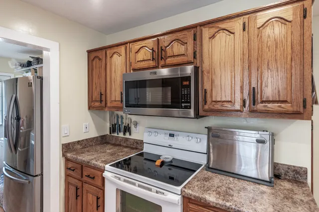 a kitchen with stainless steel appliances granite countertop a stove microwave and refrigerator