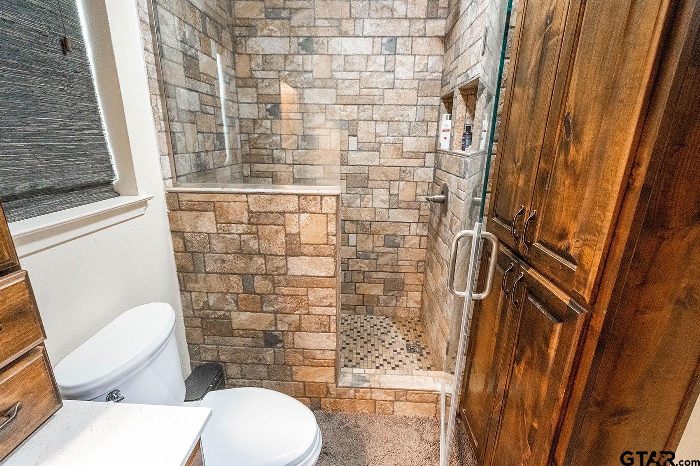 6523 North Sparta Avenue Odessa, TX 79764 - Photo 12 of 38 a bathroom with a toilet and a shower curtain