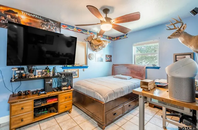 a bedroom with a bed and flat tv screen on the dresser