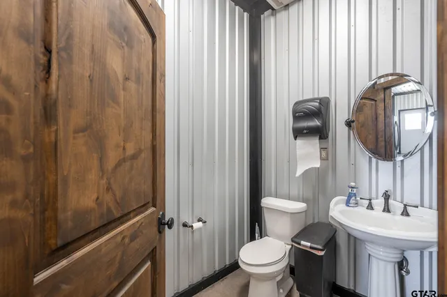 a bathroom with a toilet a sink and mirror