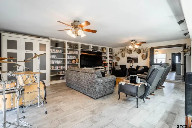 a living room with furniture a flat screen tv and kitchen view