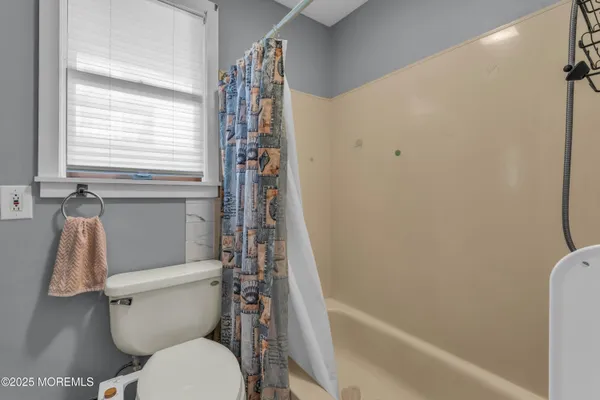 a white toilet sitting next to a bath tub