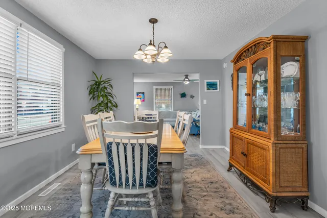 a dining room with furniture a chandelier and window