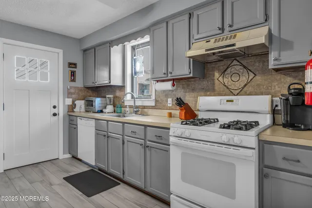 a kitchen with appliances cabinets and a stove top oven