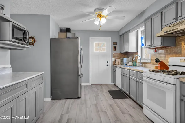 a kitchen with stainless steel appliances a refrigerator and a stove top oven