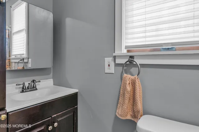 a bathroom with a sink a toilet and a window