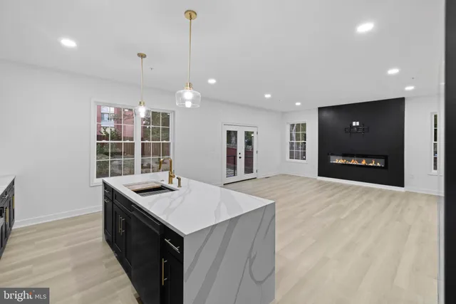 a kitchen with kitchen island a sink appliances and a counter top space