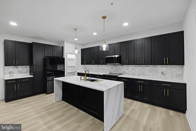 a kitchen with a sink a stove a refrigerator and cabinets