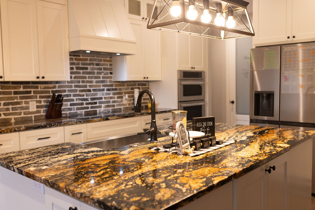 111 Powder Ridge Luling, TX 78648 - Photo 15 of 22 An inviting kitchen features a central island with a sink and luxurious granite countertops, ideal for meal preparation and entertaining.